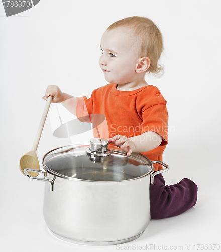 Image of baby with big cooking pot and wooden spoon