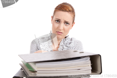 Image of business woman in office looks at unbelievable folder stack