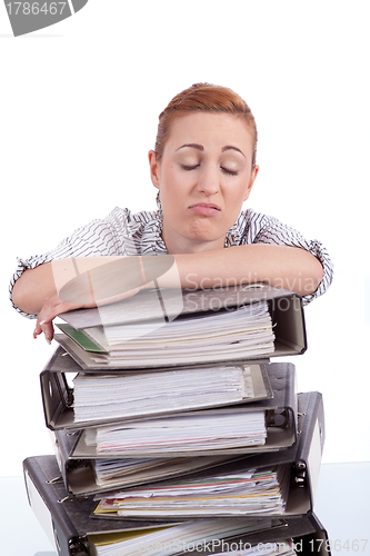 Image of business woman in office looks at unbelievable folder stack