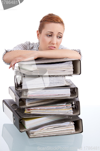 Image of business woman in office looks at unbelievable folder stack