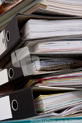 Image of business woman in office looks at unbelievable folder stack