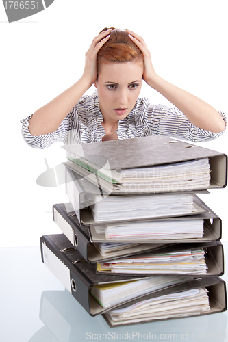 Image of business woman in office looks at unbelievable folder stack