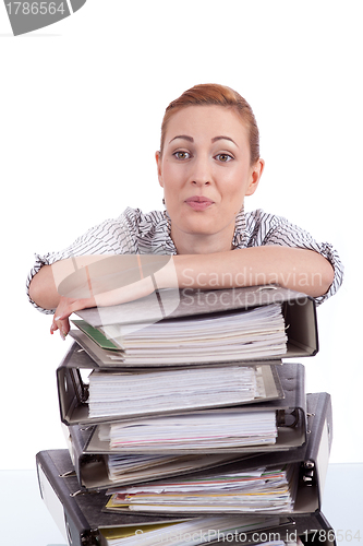 Image of business woman in office looks at unbelievable folder stack