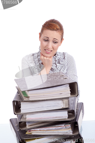 Image of business woman in office looks at unbelievable folder stack