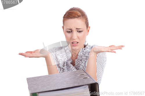 Image of business woman in office looks at unbelievable folder stack