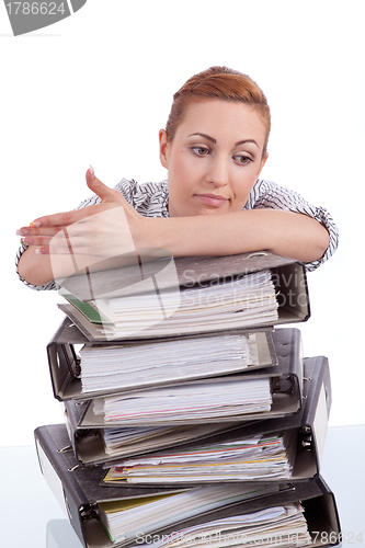 Image of business woman in office looks at unbelievable folder stack