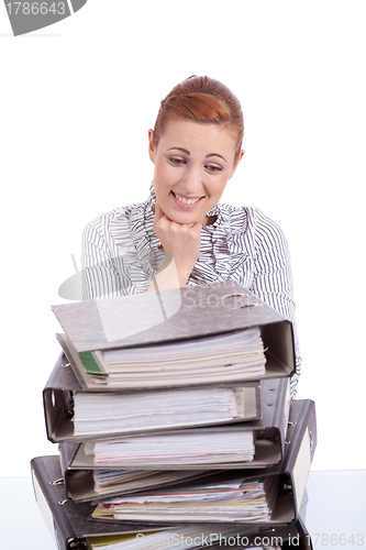 Image of business woman in office looks at unbelievable folder stack