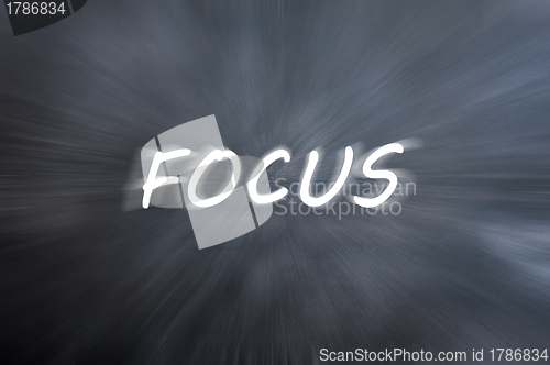 Image of Focus word with motion rays on retro blackboard background 