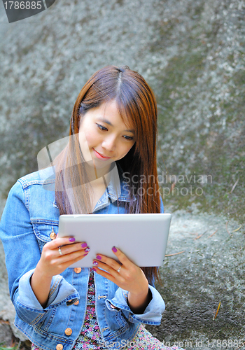 Image of young asian woman with tablet computer outdoor