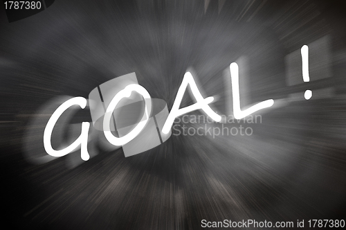 Image of Chalk drawing of "Goal" word written on a blurred chalkboard with motion rays