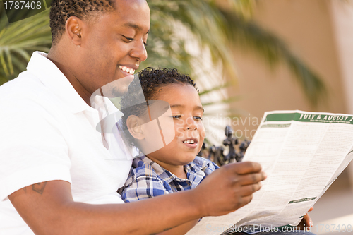 Image of Mixed Race Father and Son Reading Park Brochure Outside