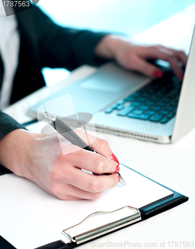 Image of Closeup of woman copying data from laptop