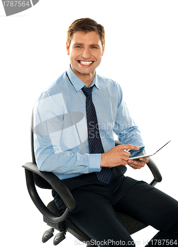 Image of Seated young executive using tablet pc
