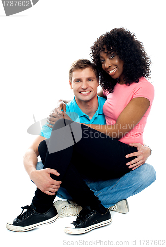 Image of African teenager sitting on boyfriends lap