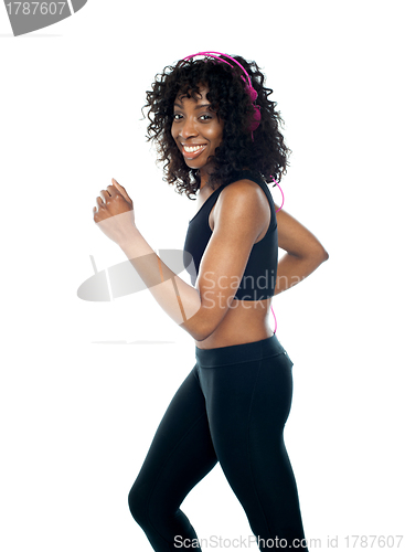 Image of Female athlete running and tuned into music