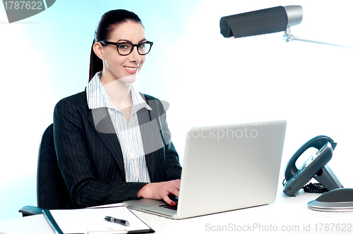 Image of Smiling female secretary working on laptop