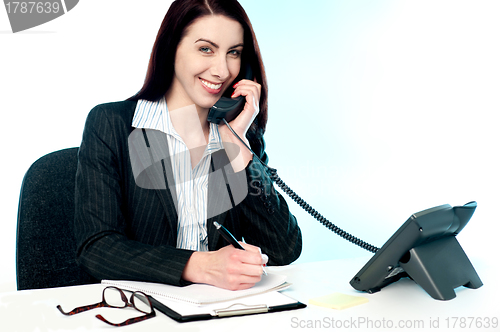 Image of Operator receiving call on telephone and writing