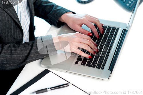 Image of Females hands typing on laptop keypad. Cropped image