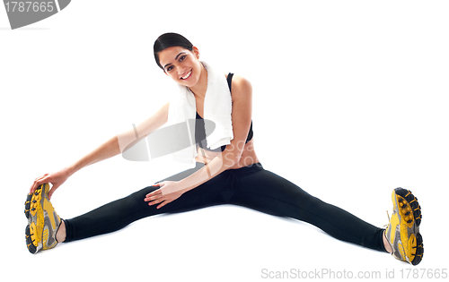 Image of Young fit female trainer doing stretching