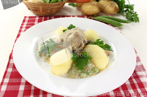 Image of cooked meatballs in a white sauce with capers