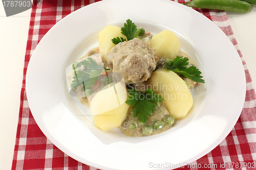 Image of cooked meatballs in a white sauce with capers