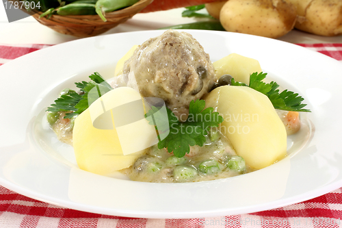 Image of cooked meatballs in a white sauce with capers