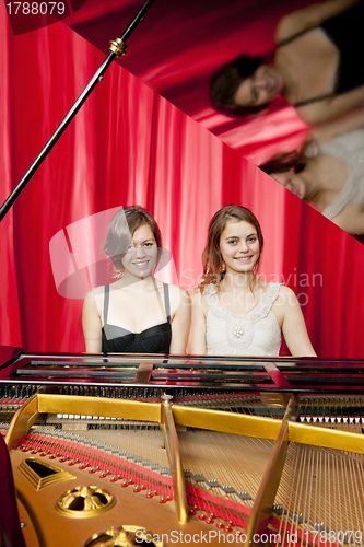 Image of Pretty girls play two part harmony on a piano