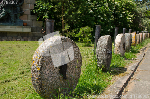 Image of Retro rock millstones hang. Car park decorations 