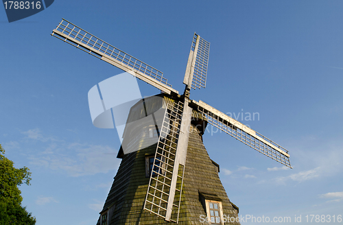 Image of Retro wooden mill  wings against blue sky 