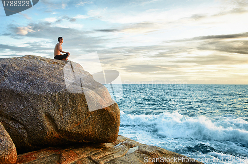 Image of Man practices yoga on coast - meditation