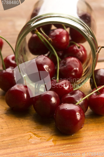 Image of Cherry in glass jar isolated on the wooden background