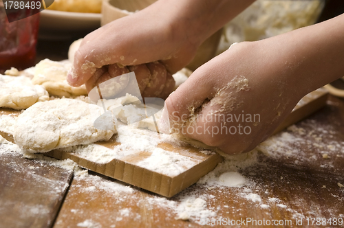 Image of Detail of hands kneading dough