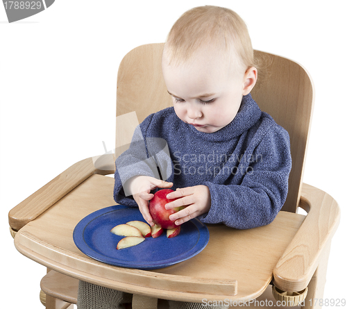 Image of young child eating peaches in high chair