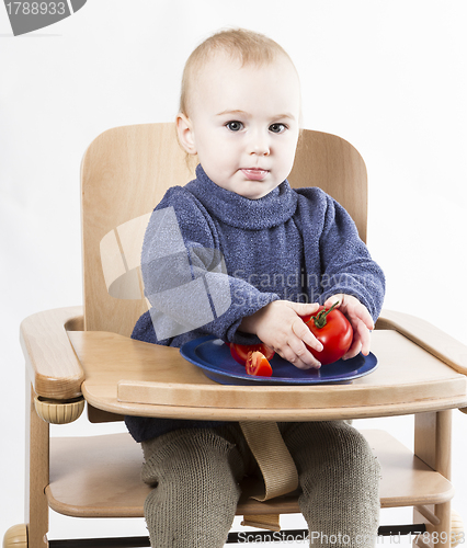 Image of young child eating in high chair