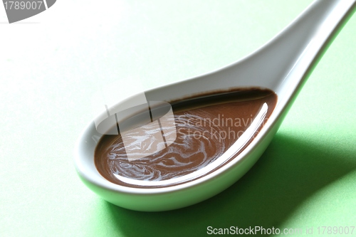 Image of chocolate sauce on a porcelain spoon