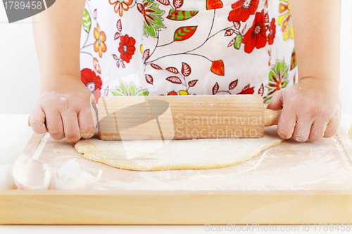 Image of Woman rolling dough using rolling pin