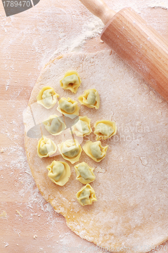 Image of Dough with raw tortellini and rolling pin