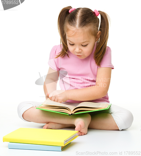 Image of Cute little girl reads a book
