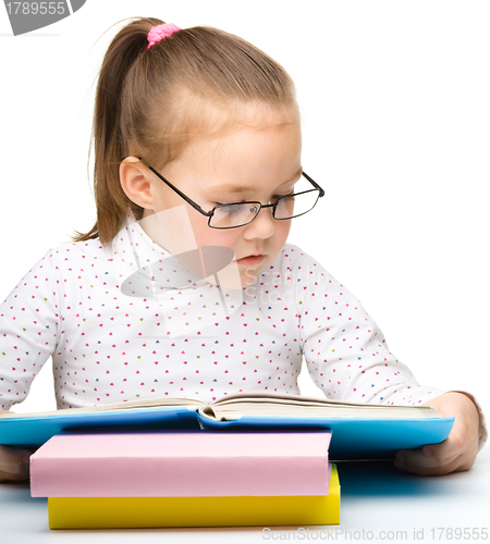 Image of Cute little girl is reading book