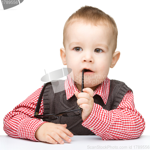 Image of Cute little child is biting glasses