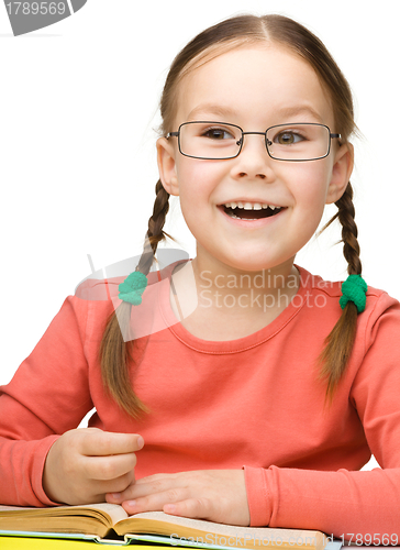 Image of Cute cheerful little girl reading book