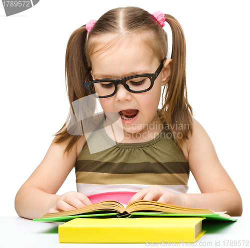 Image of Cute little girl is reading book