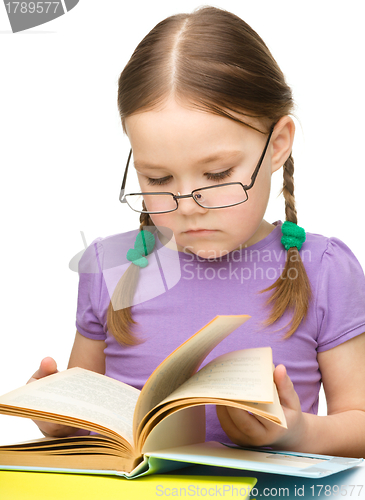 Image of Cute little girl reading book wearing glasses