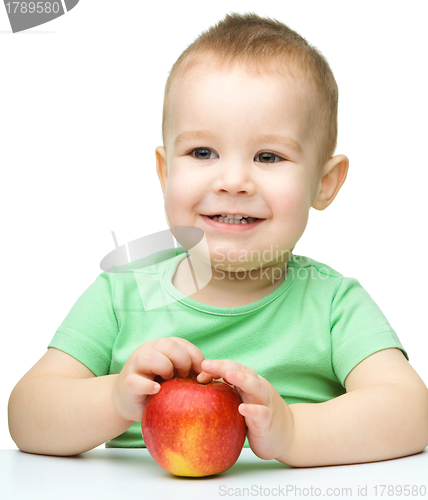 Image of Portrait of a cute cheerful little boy with apple