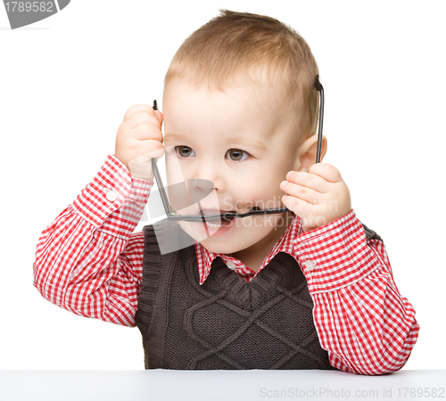 Image of Cute little child is biting glasses