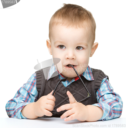 Image of Cute little child is biting glasses