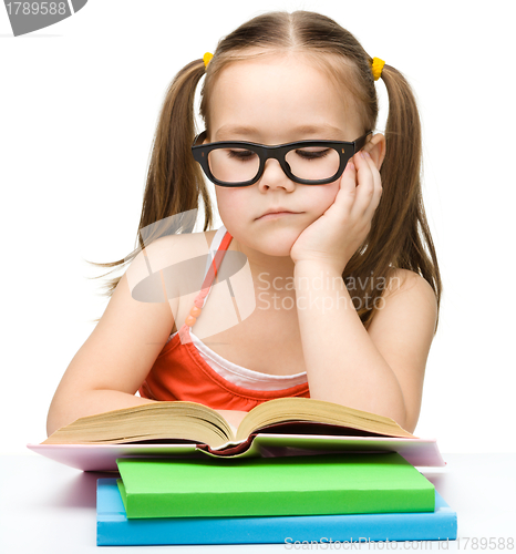Image of Cute little girl is reading book
