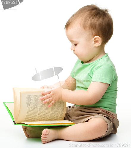 Image of Cute little boy reads a book