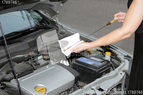 Image of Woman checking oil engine level 2