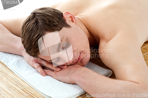 Image of Young man relaxing at spa centre